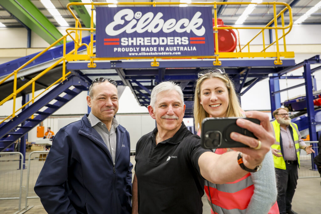 Three open day guests take a selfie in front of the Eilbeck Shredders line