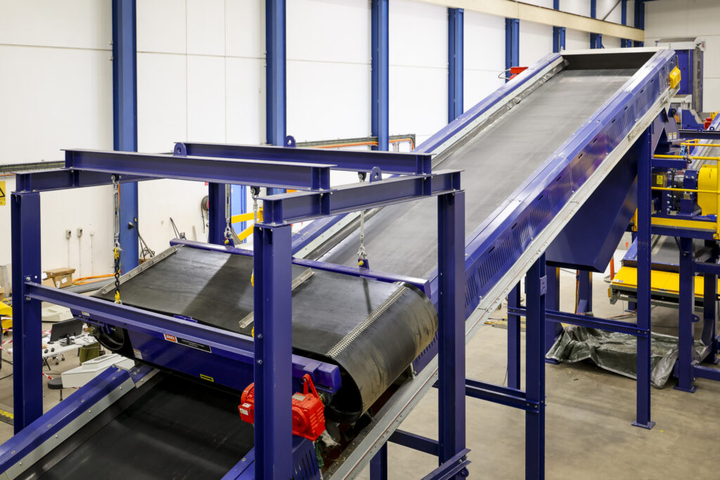 A blue inclined belt conveyor in the Eilbeck workshop
