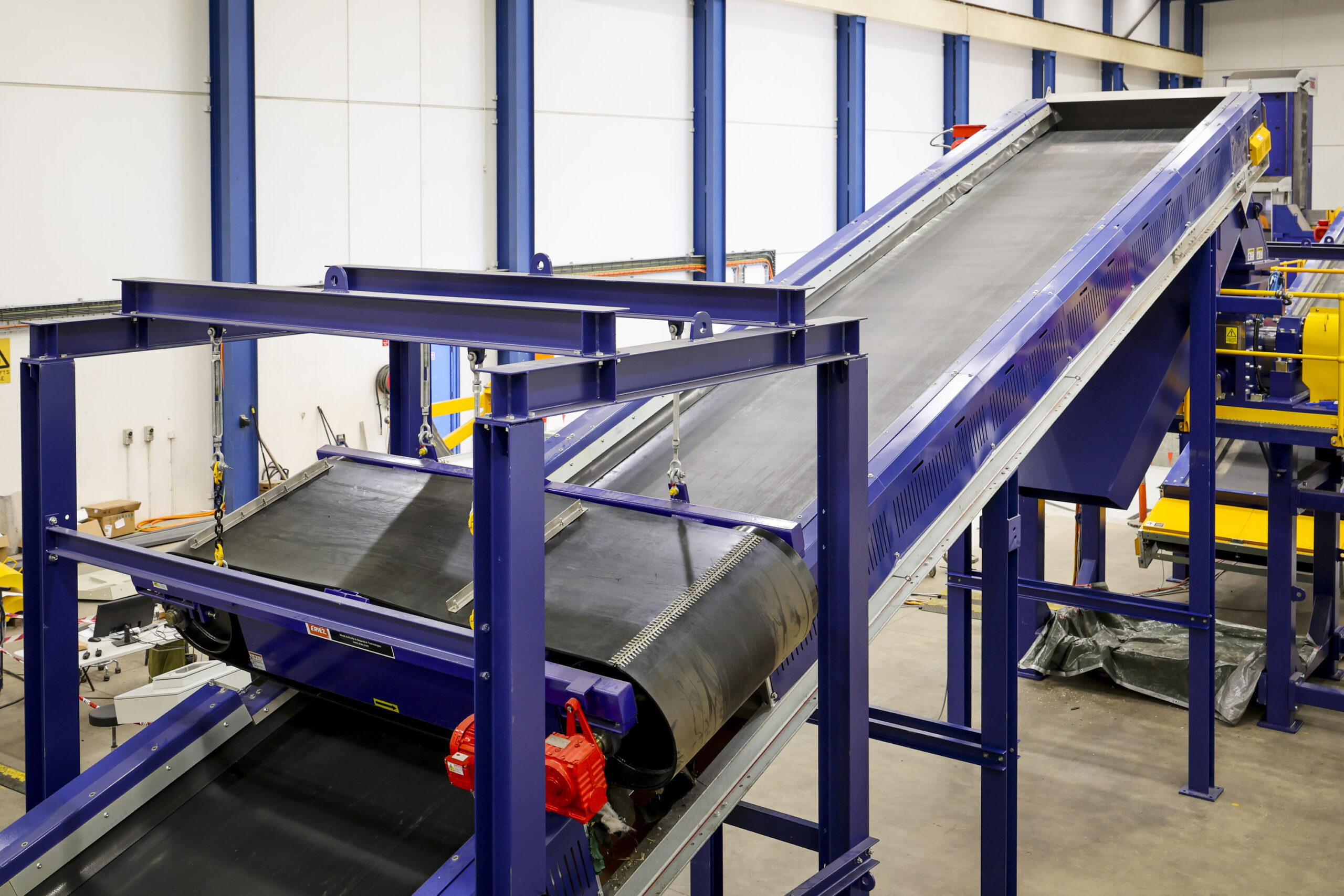 A blue inclined belt conveyor in the Eilbeck workshop